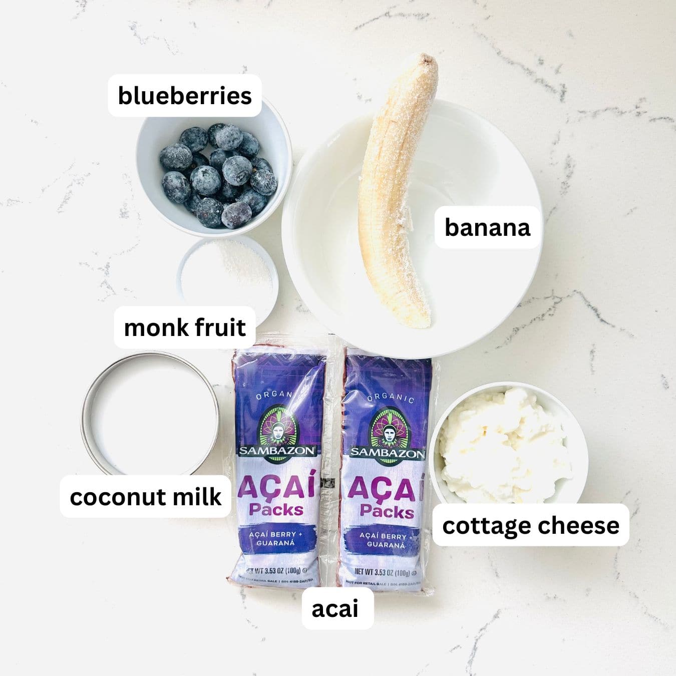 Ingredient for acai smoothie bowl on a marble table and showing with labels.