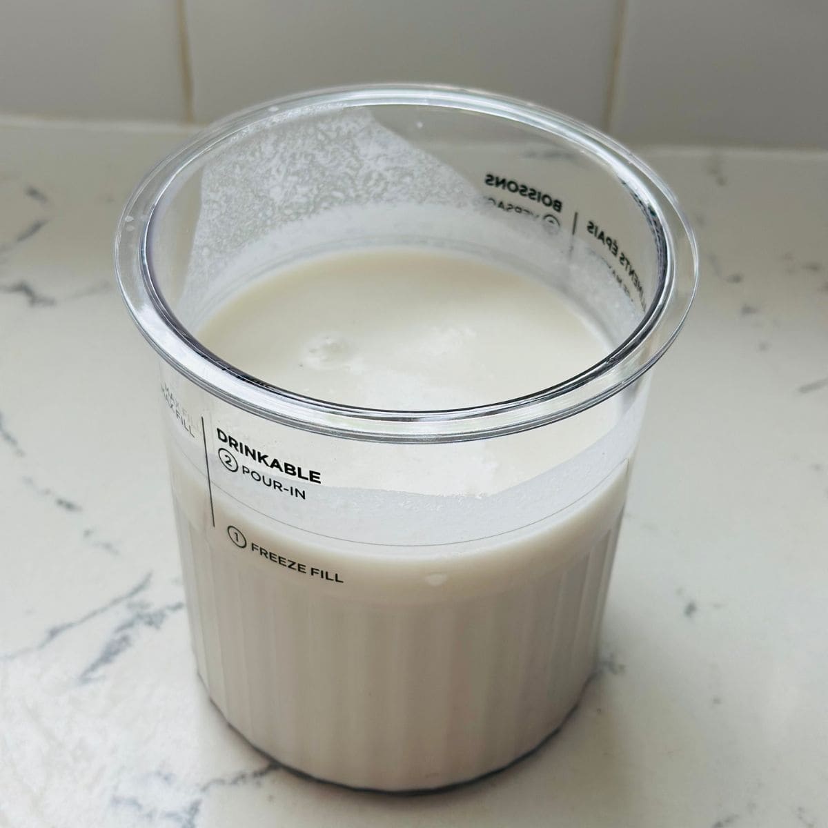 Mixture of high-protein vanilla ice cream in a ninja container pint ready to be frozen.