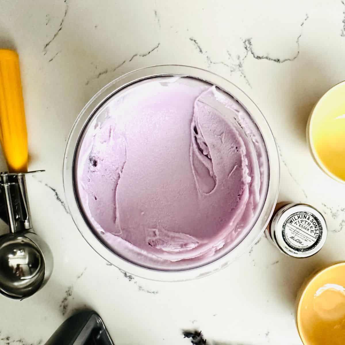 Scoop of lavender honey ice cream showing smooth texture ready to be enjoyed.