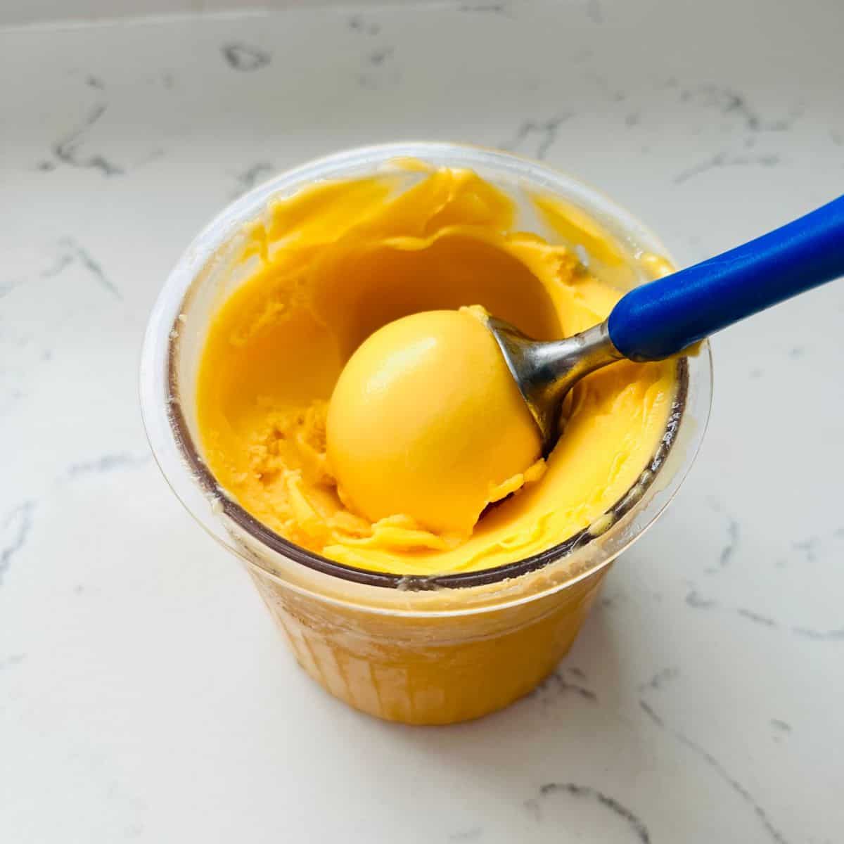 Scoop of Peach and mango sorbet ready to be enjoyed.