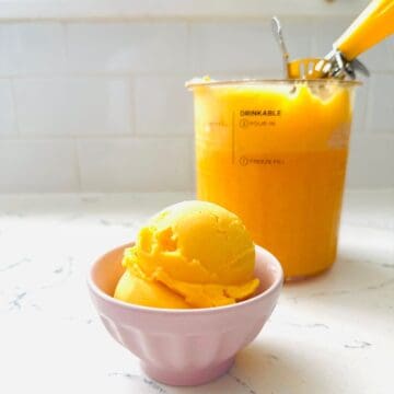 Scoops of Peach and mango sorbet in a bowl ready to be enjoyed.