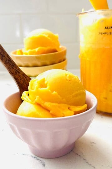 Scoops of Peach and mango sorbet in a bowl ready to be enjoyed.