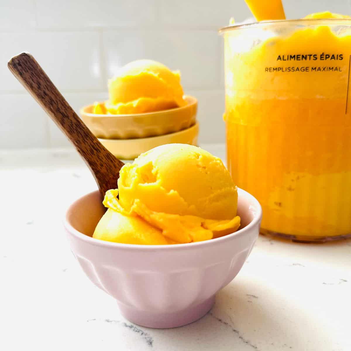 Scoops of Peach and mango sorbet in a bowl ready to be enjoyed.