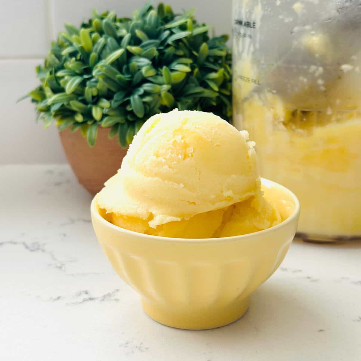 Scoops of dole whip ice cream on a yellow bowl ready to be enjoyed.