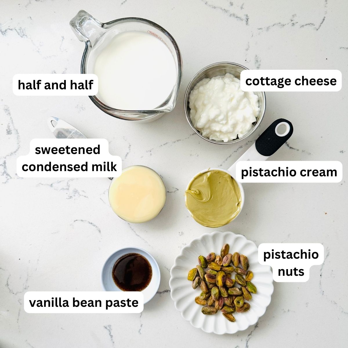 Ingredients for pistachio ice cream arranged neatly in a marble table.