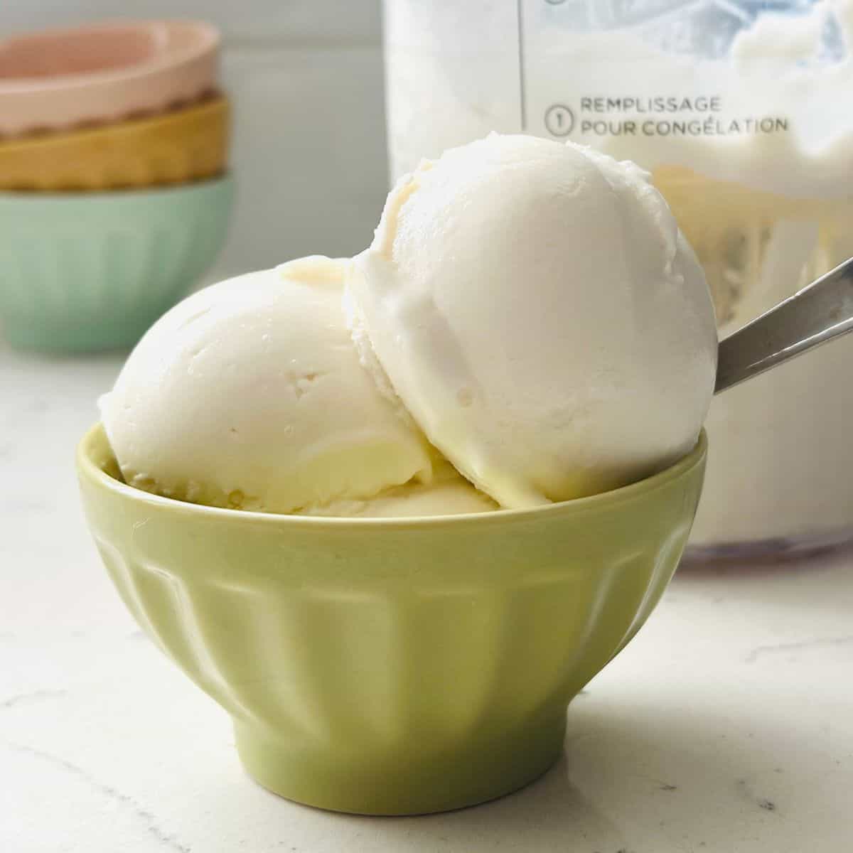 Scoops of plain tart frozen yogurt in a bowl ready for serving.