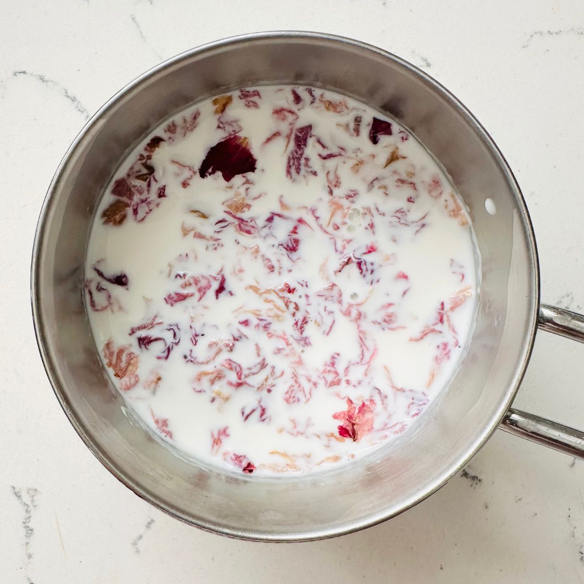 Steeping rose petals for rose ice cream.