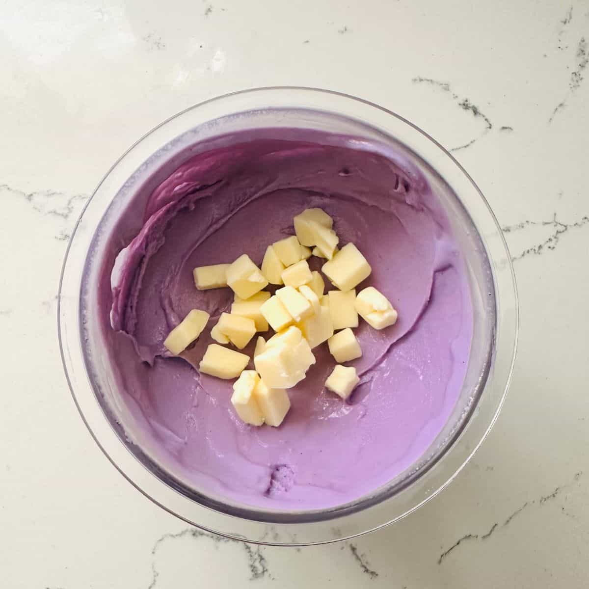 Ube Ice Cream topped with cheese in a ninja creami pint ready to be enjoyed.