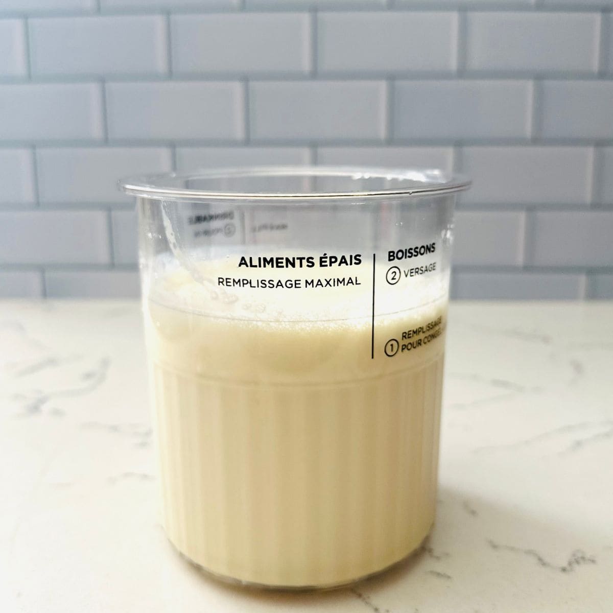 Homemade birthday cake ice cream mixture in a Ninja Creami pint ready for freezing.