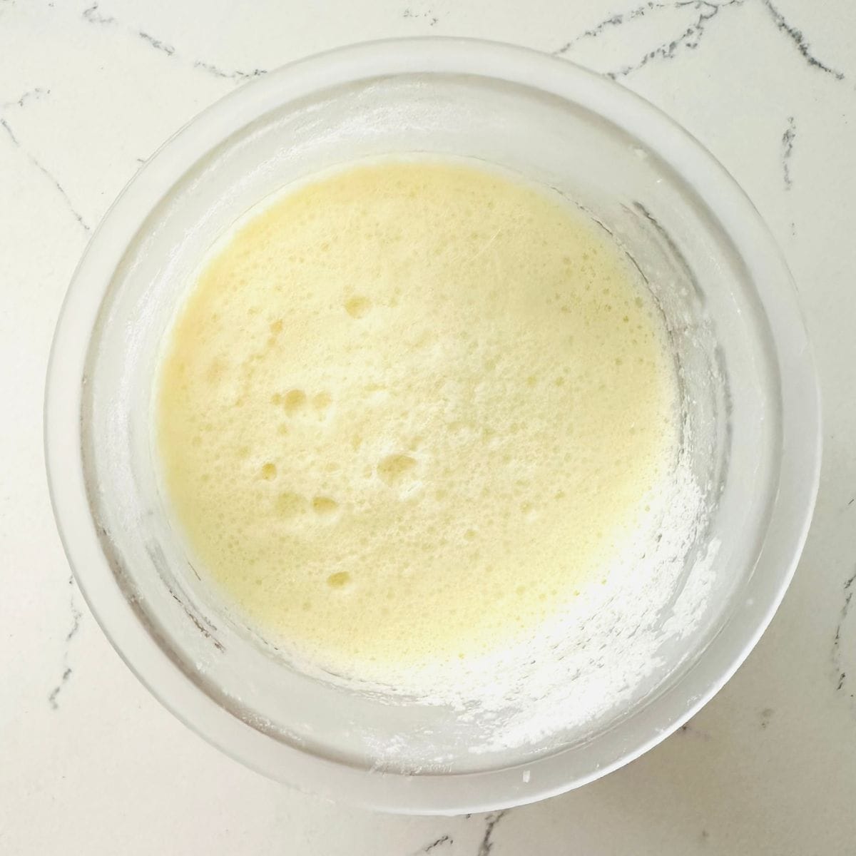 Frozen homemade birthday cake ice cream mixture in a Ninja Creami pint.