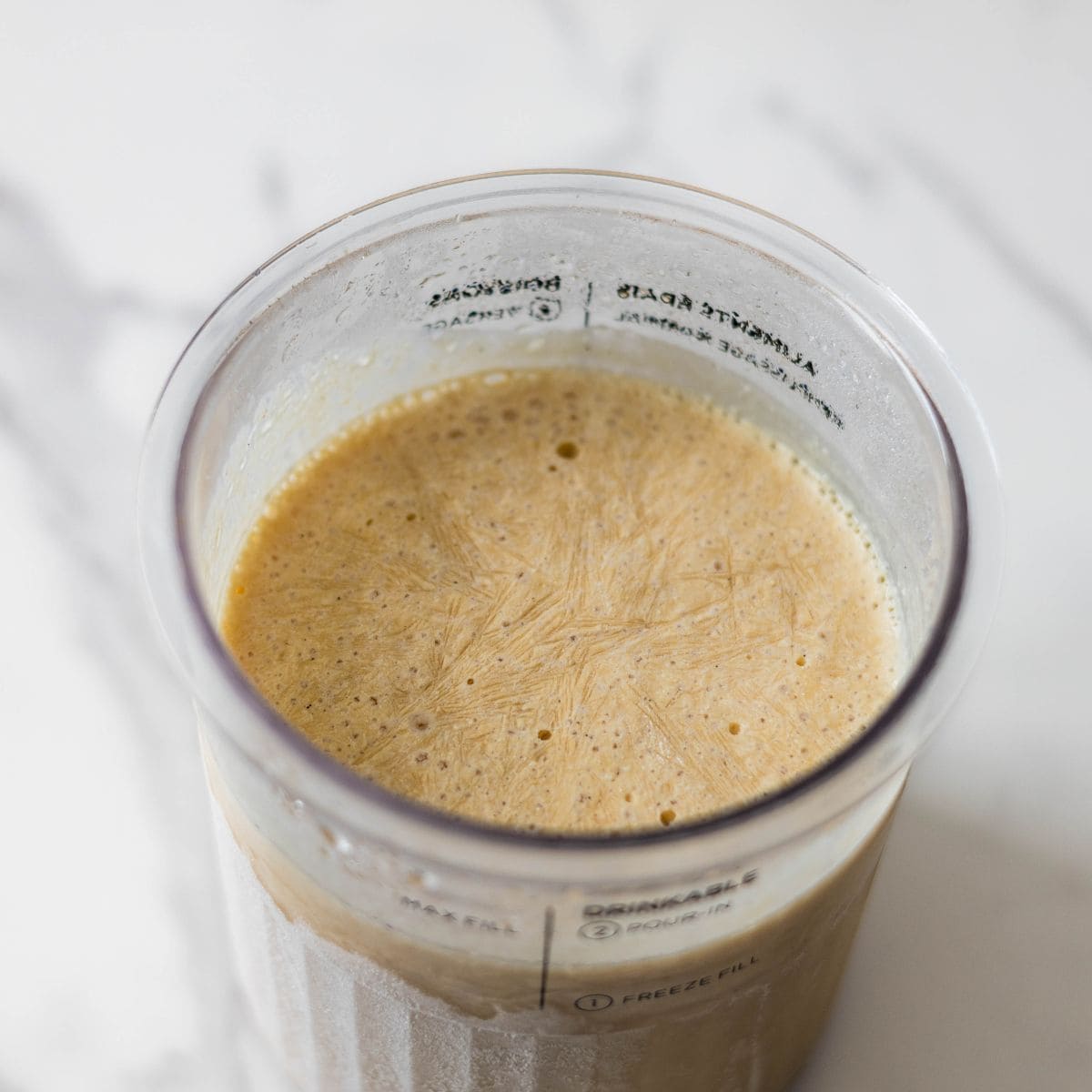 Frozen Ninja Creami PB2 peanut butter ice cream ready to be spun.