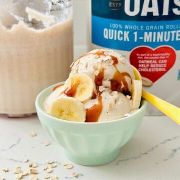 Scoops of Ninja Creami Overnight Oats Ice Cream topped with oats and fruit in a bowl.