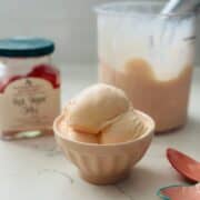 Small bowl with scoops of homemade red pepper jelly ice cream made in the Ninja Creami, showing creamy smooth texture and light peach color.