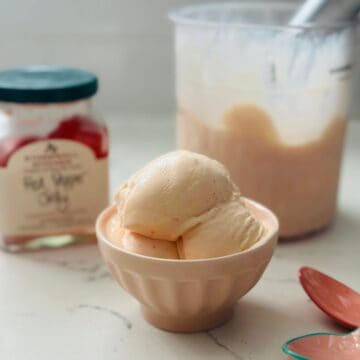Small bowl with scoops of homemade red pepper jelly ice cream made in the Ninja Creami, showing creamy smooth texture and light peach color.