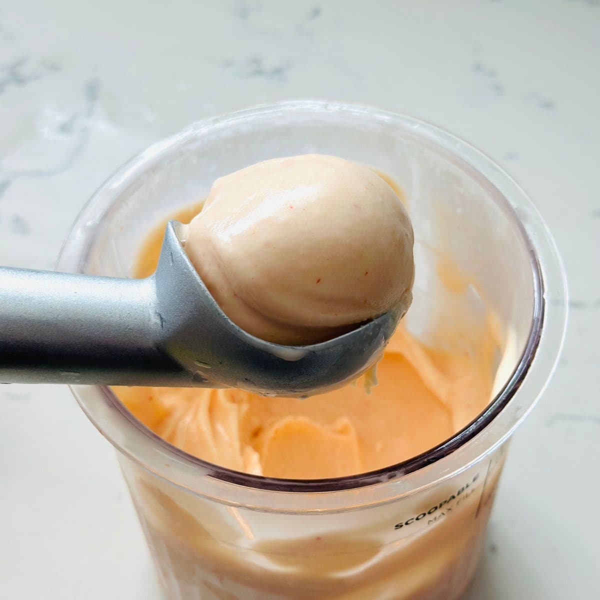 Scooping creamy red pepper jelly ice cream from Ninja Creami pint after final spin.