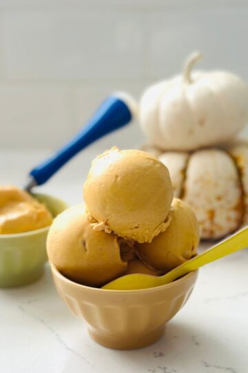 Scoops of Ninja Creami Pumpkin Cheesecake Ice Cream served in bowl with graham cracker topping.