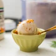 Bowl of Ninja Creami maple cinnamon crunch ice cream with maple drizzle and cinnamon crunch on top.