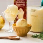 Scoop of eggnog ice cream on a bowl topped with cinnamon powder on top.