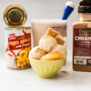 Ninja Creami apple cinnamon pie ice cream served in a bowl with warm cinnamon apple pieces and a sprinkle of pie crust crumble.