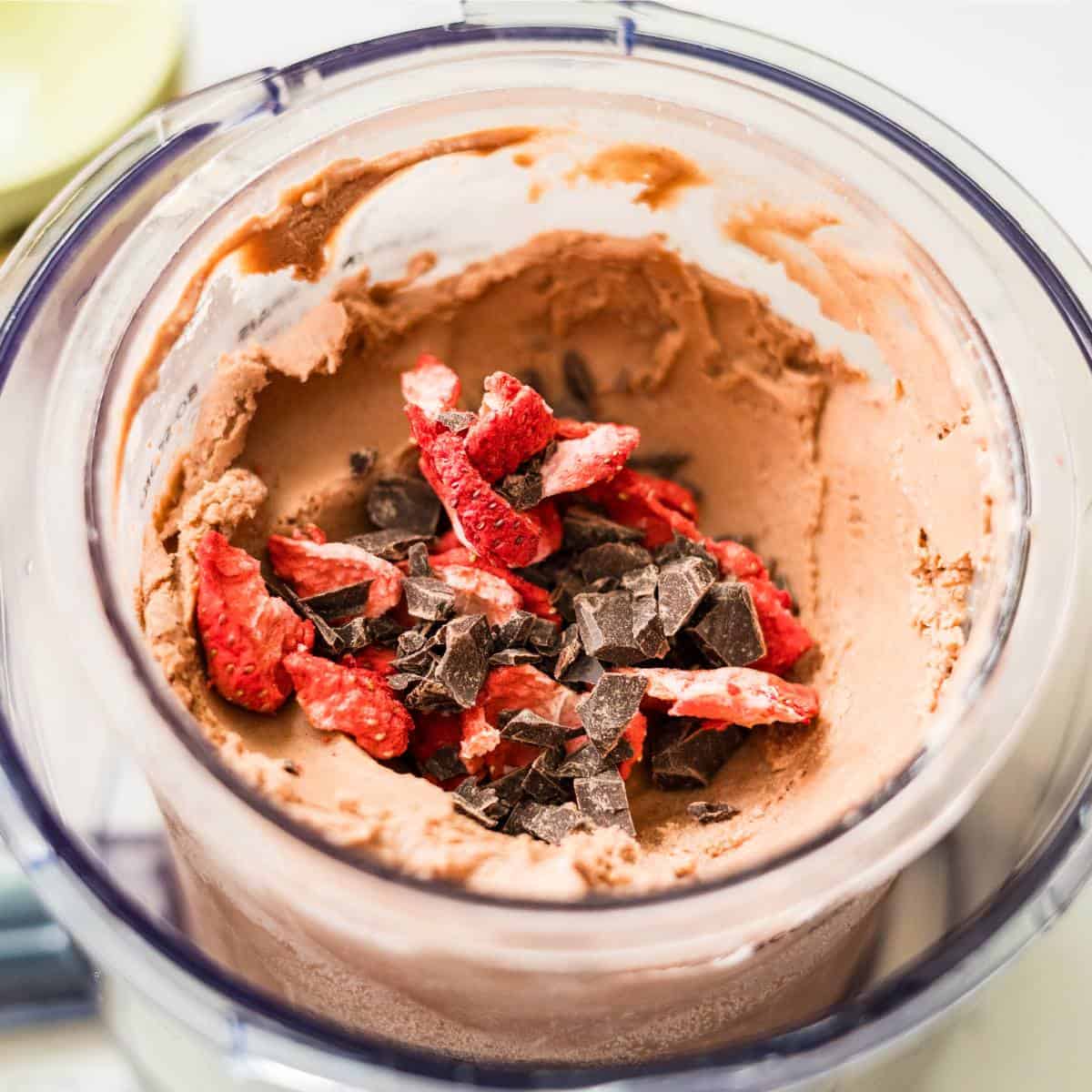 Chocolate strawberry Ninja Creami ice cream topped with chopped strawberries and chocolate shaving.