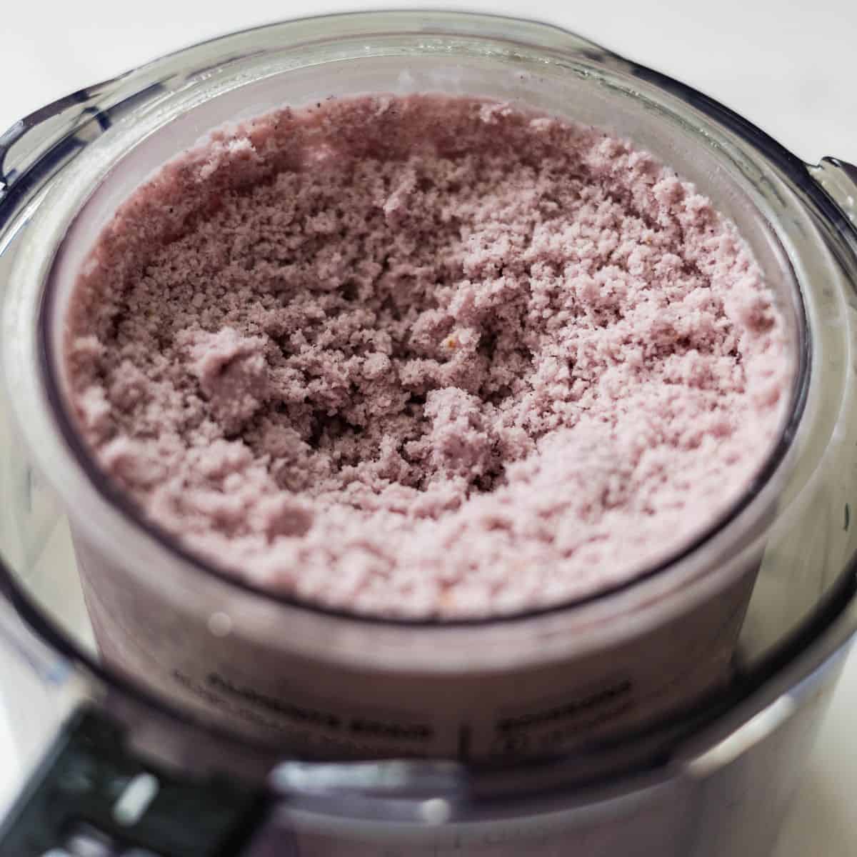 Mixed berry Ninja Creami ice cream after the first spin, showing a crumbly texture before respinning.