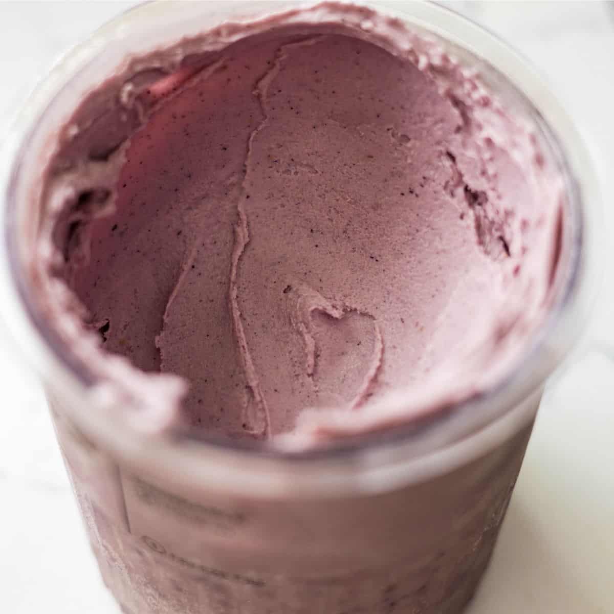 Smooth and creamy mixed berry Ninja Creami ice cream in the pint after respinning, with a soft pastel purple color.