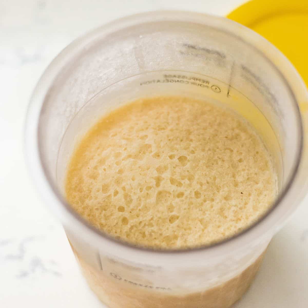 Frozen banana ice cream base in a Ninja Creami pint before spinning.