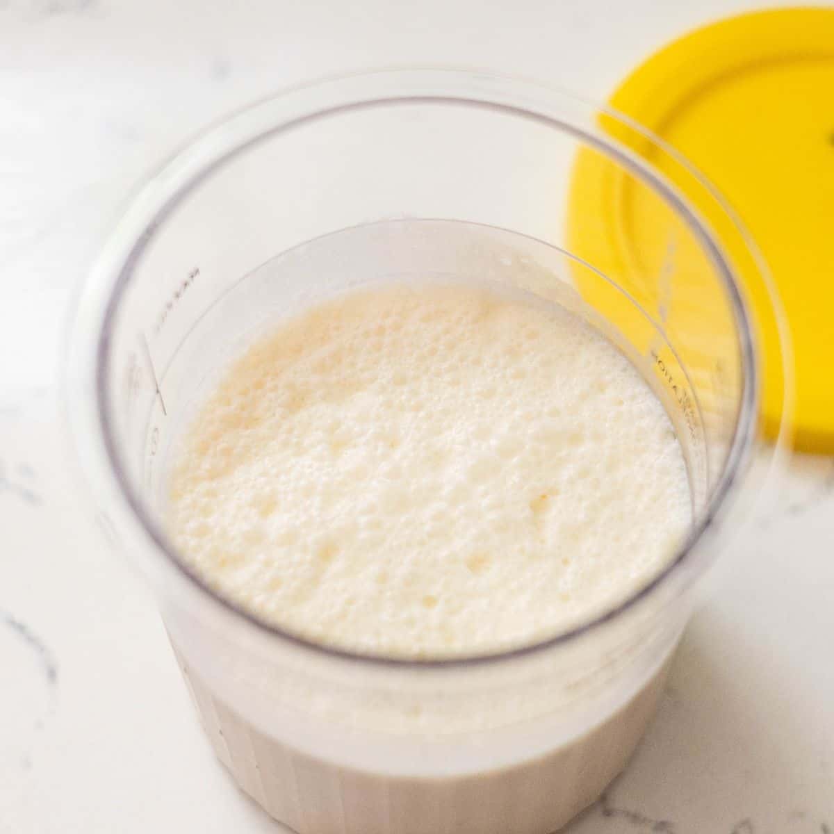 Frozen banana ice cream base in a Ninja Creami pint before spinning.