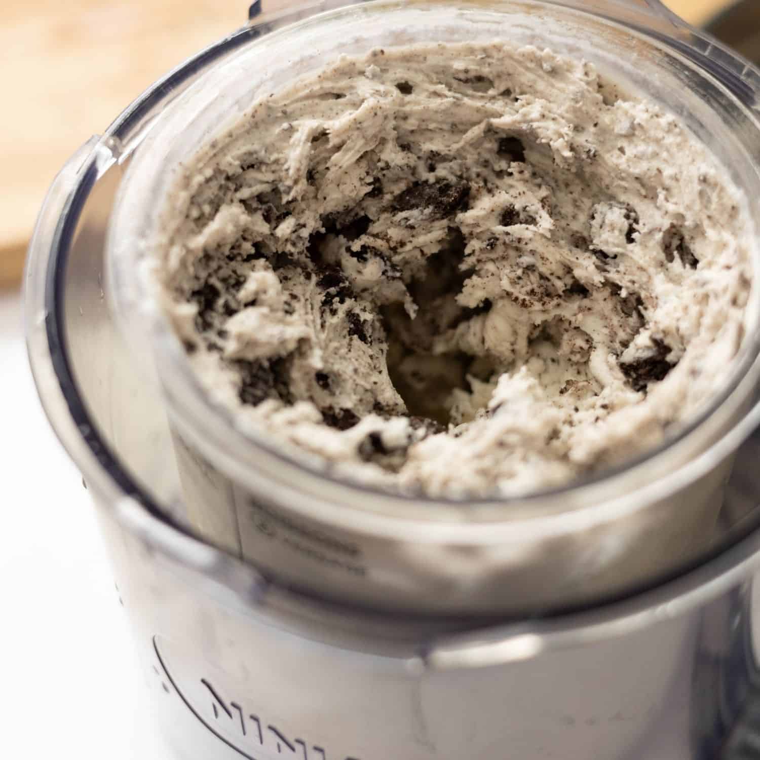 Creamy high protein cookies and cream ice cream in a Ninja Creami pint after spinning, ready to scoop and serve.