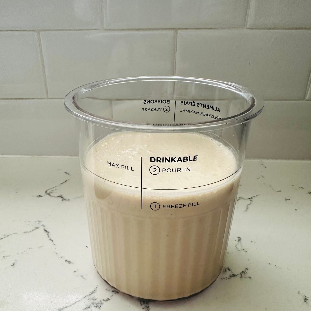 Ninja Creami peanut butter cup ice cream base blended and poured into Deluxe pint before freezing