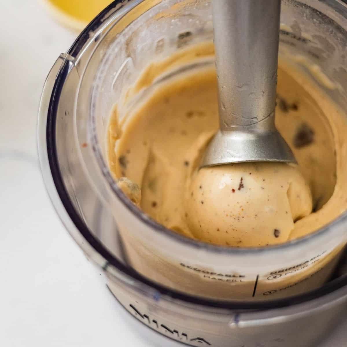 Scoop of Ninja Creami high protein peanut butter cup ice cream inside the pint container showing creamy texture and candy pieces