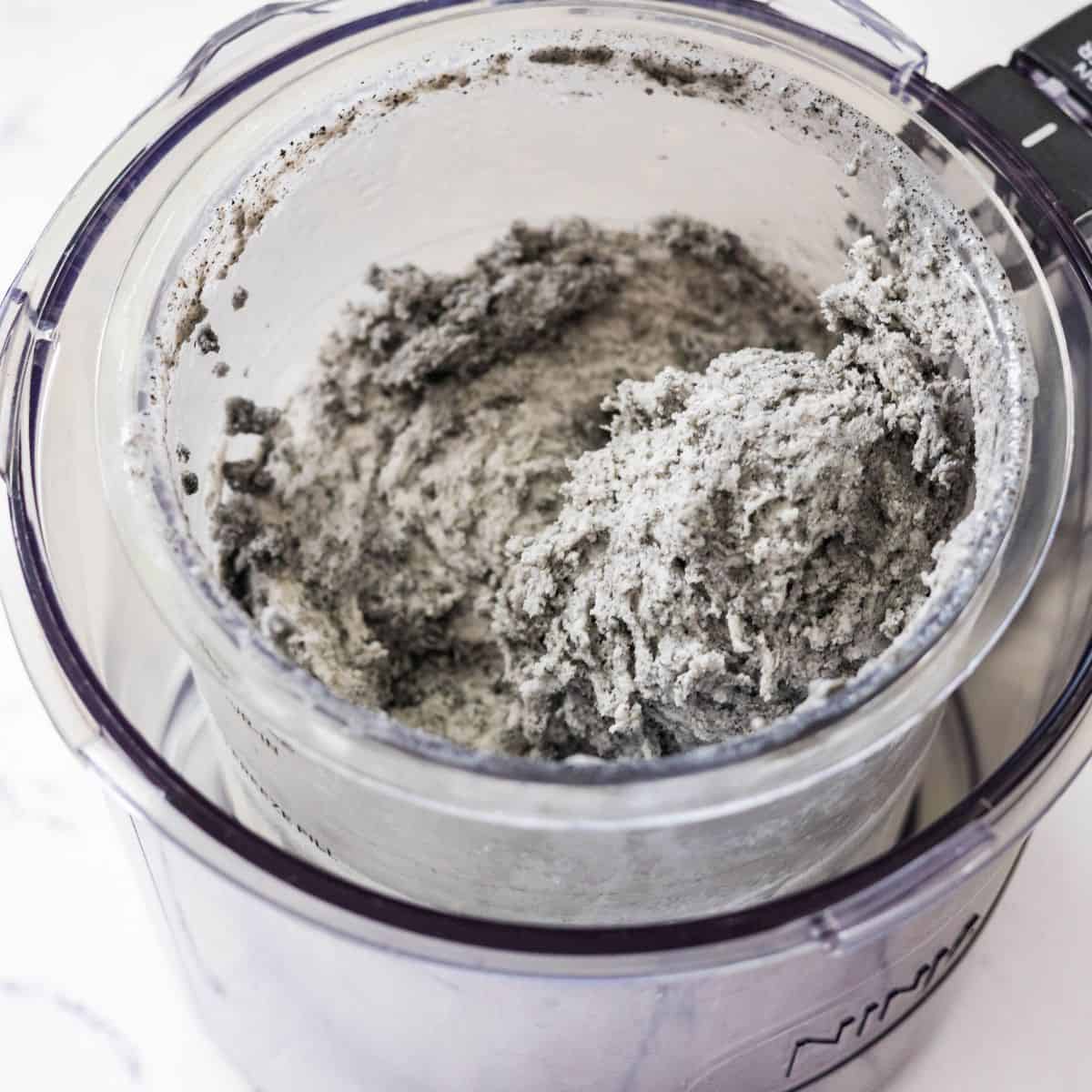 Ninja Creami black sesame ice cream after the first spin with a crumbly texture in the pint container