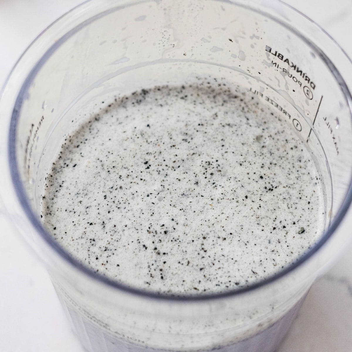Blended black sesame ice cream base in a Ninja Creami pint ready to freeze