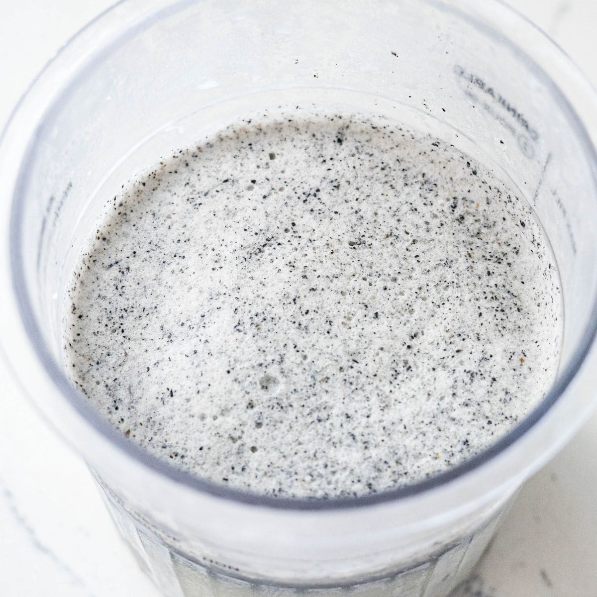 Frozen black sesame ice cream base in a Ninja Creami pint before spinning