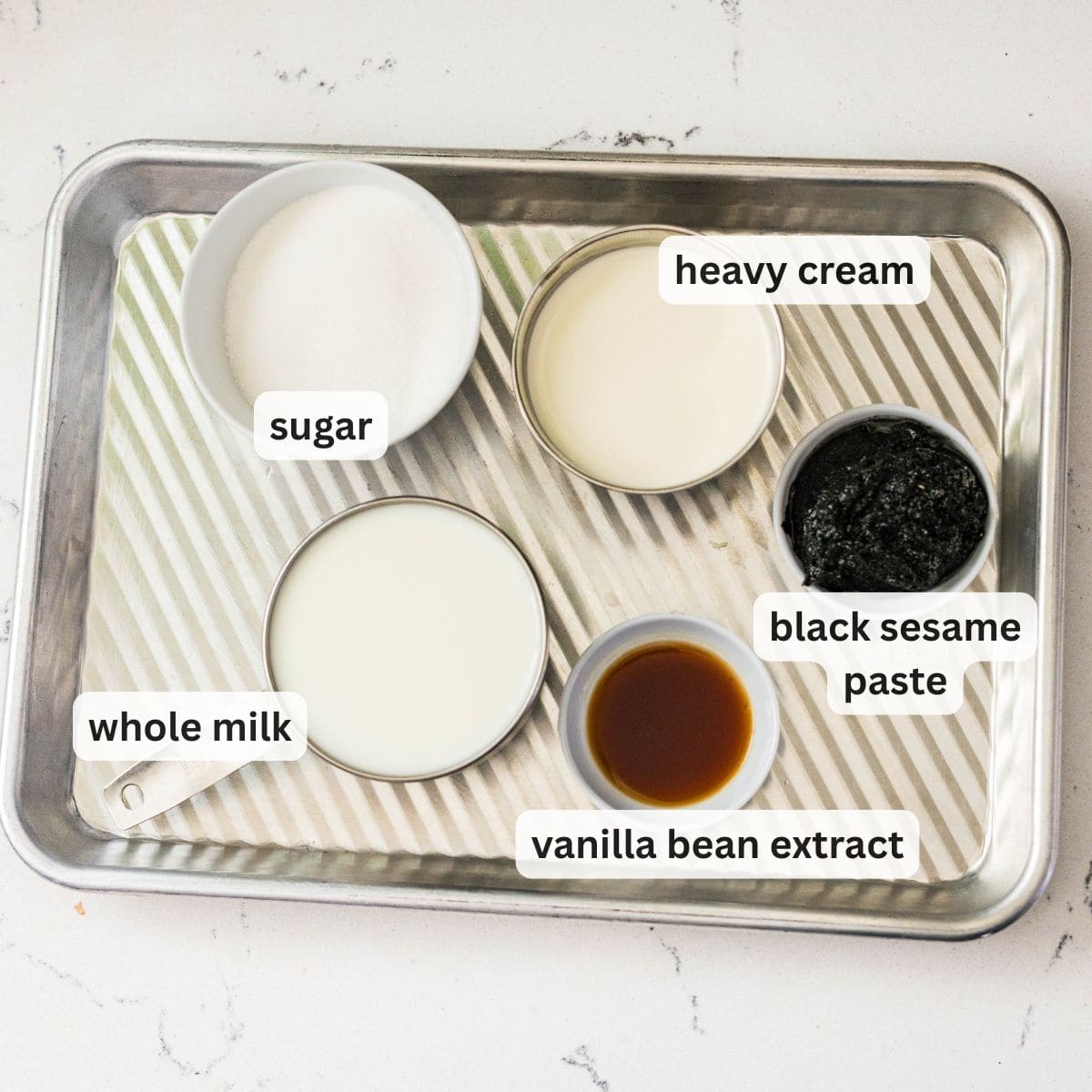 Ingredients for Ninja Creami black sesame ice cream including milk, heavy cream, sugar, vanilla, and black sesame paste