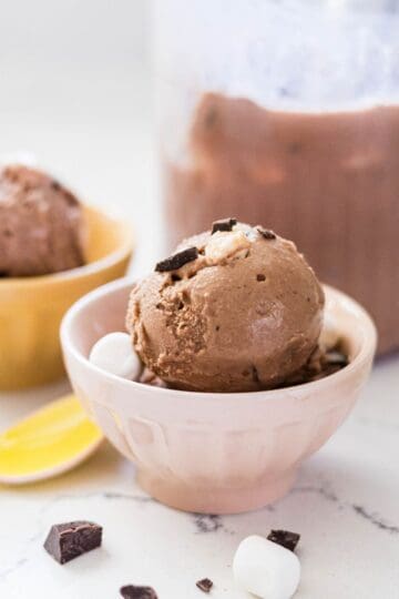 Homemade Ninja Creami rocky road ice cream served in a bowl with the pint in the background