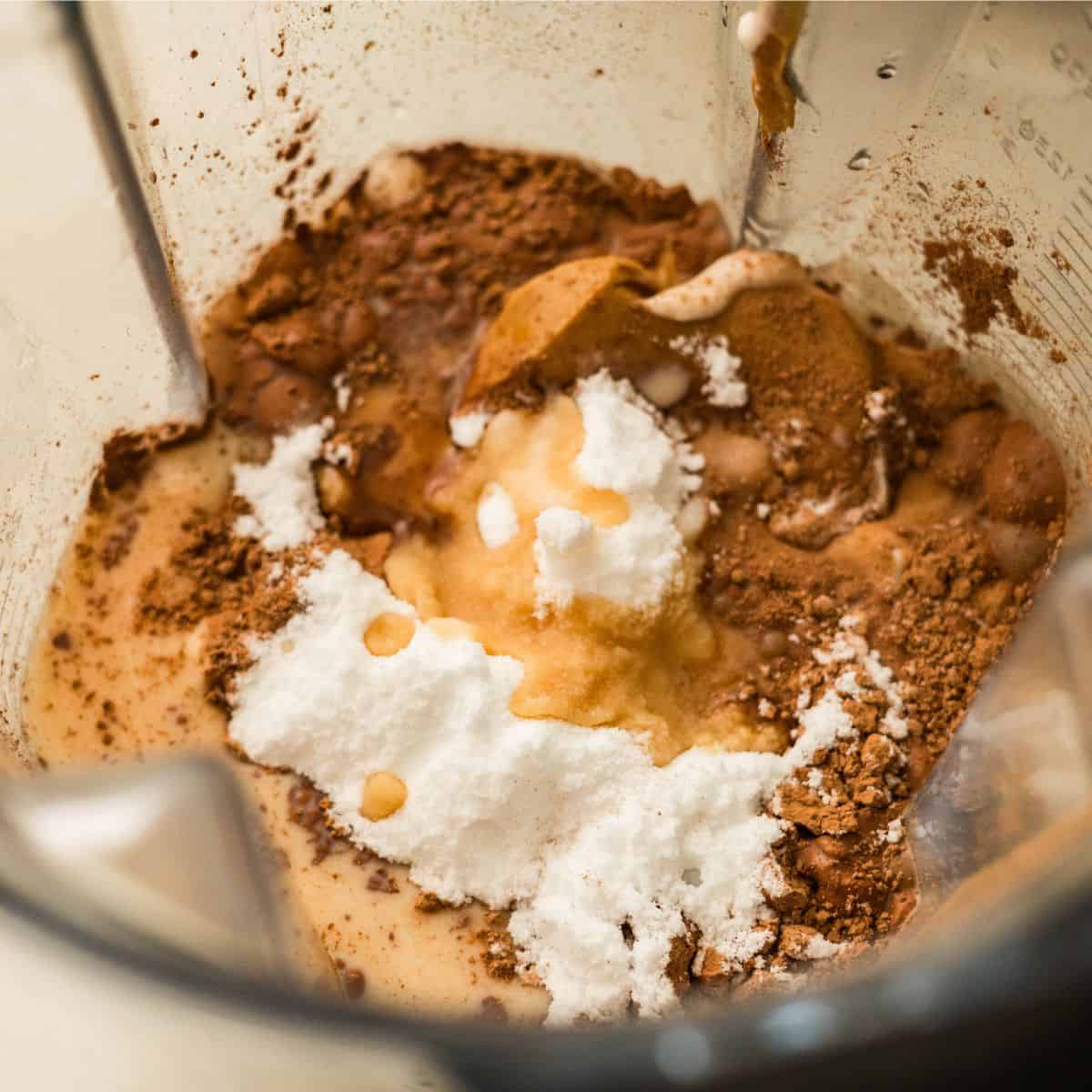 Cocoa powder, powdered peanut butter, cottage cheese, and allulose in a blender for high protein chocolate peanut butter ice cream