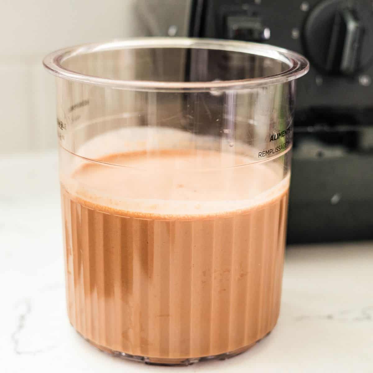 Blended chocolate peanut butter protein ice cream base in a Ninja Creami pint before freezing