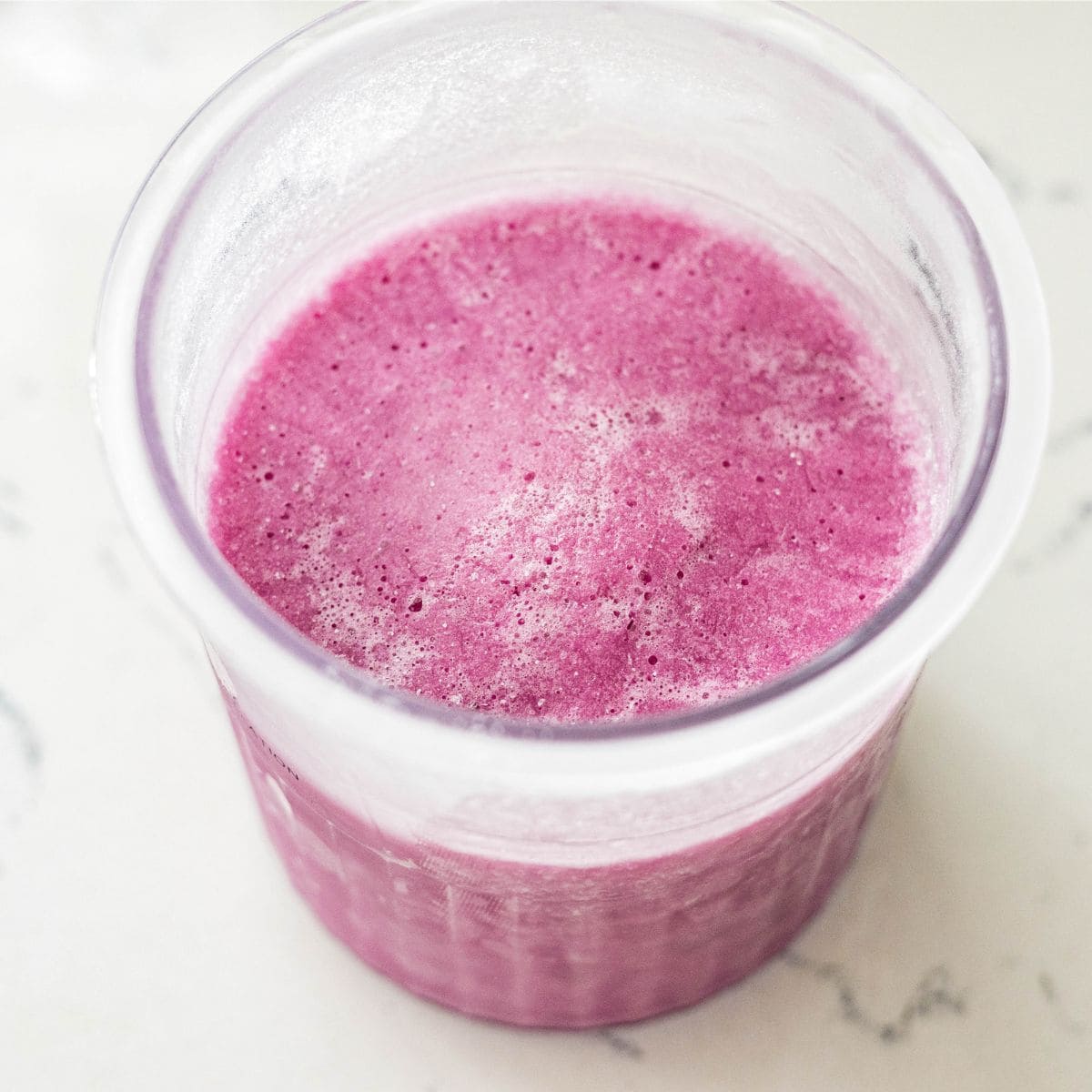 Frozen purple sweet potato protein ice cream base in a Ninja Creami pint, ready to spin