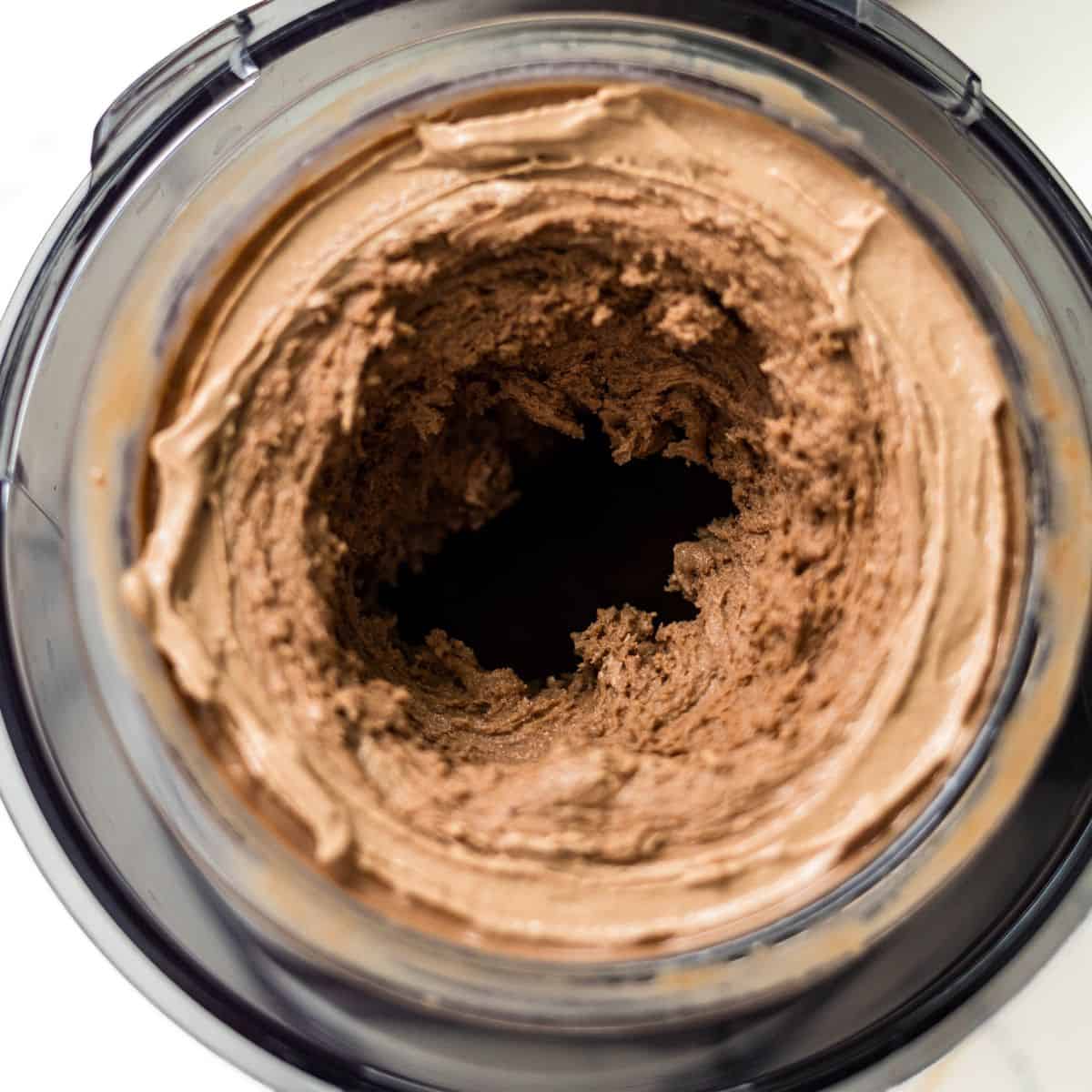 Chocolate peanut butter ice cream in a Ninja Creami pint after a second spin, starting to turn smooth