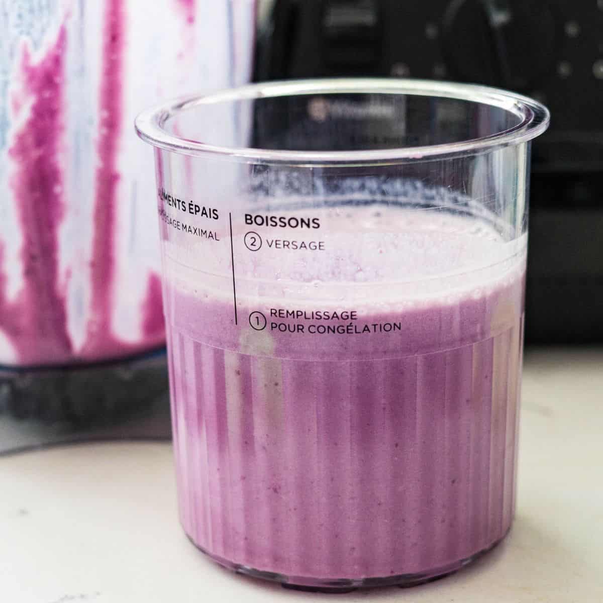 Blended purple sweet potato protein ice cream base poured into a Ninja Creami pint before freezing