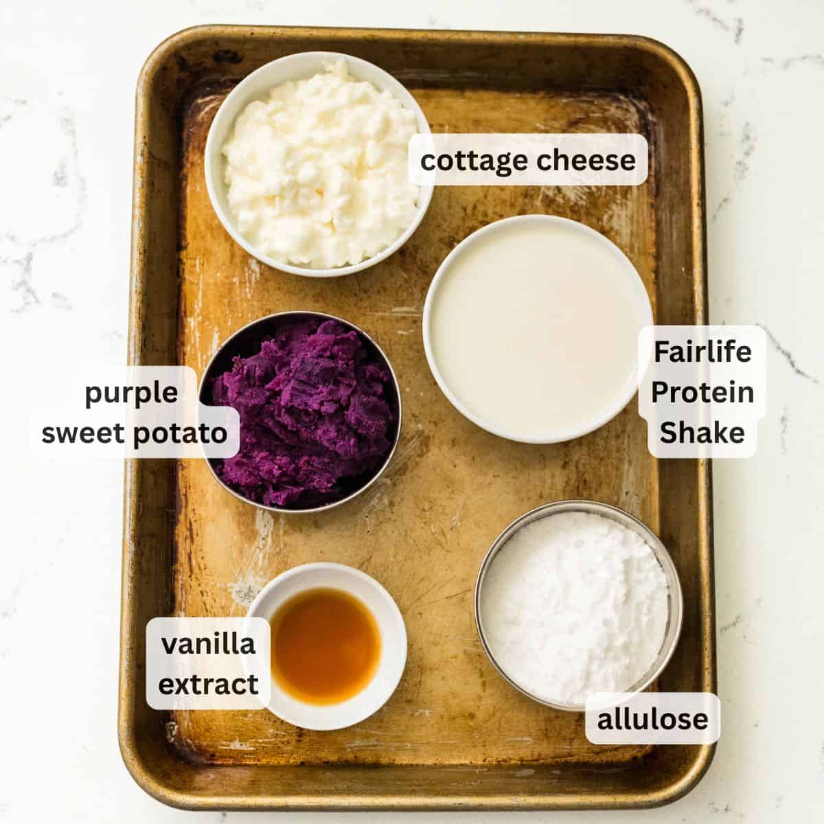 Ingredients for purple sweet potato protein ice cream on a baking tray: mashed purple sweet potato, cottage cheese, Fairlife protein shake, allulose, and vanilla extract