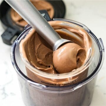 Ice cream scoop lifting chocolate peanut butter ice cream from a Ninja Creami pint