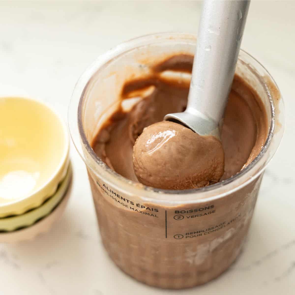 Chocolate protein ice cream being scooped from a Ninja Creami pint
